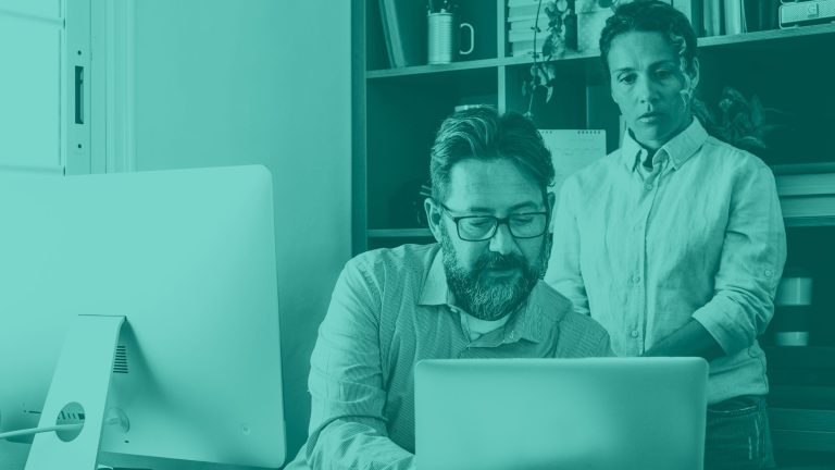 two IT leaders looking at a Chromebook