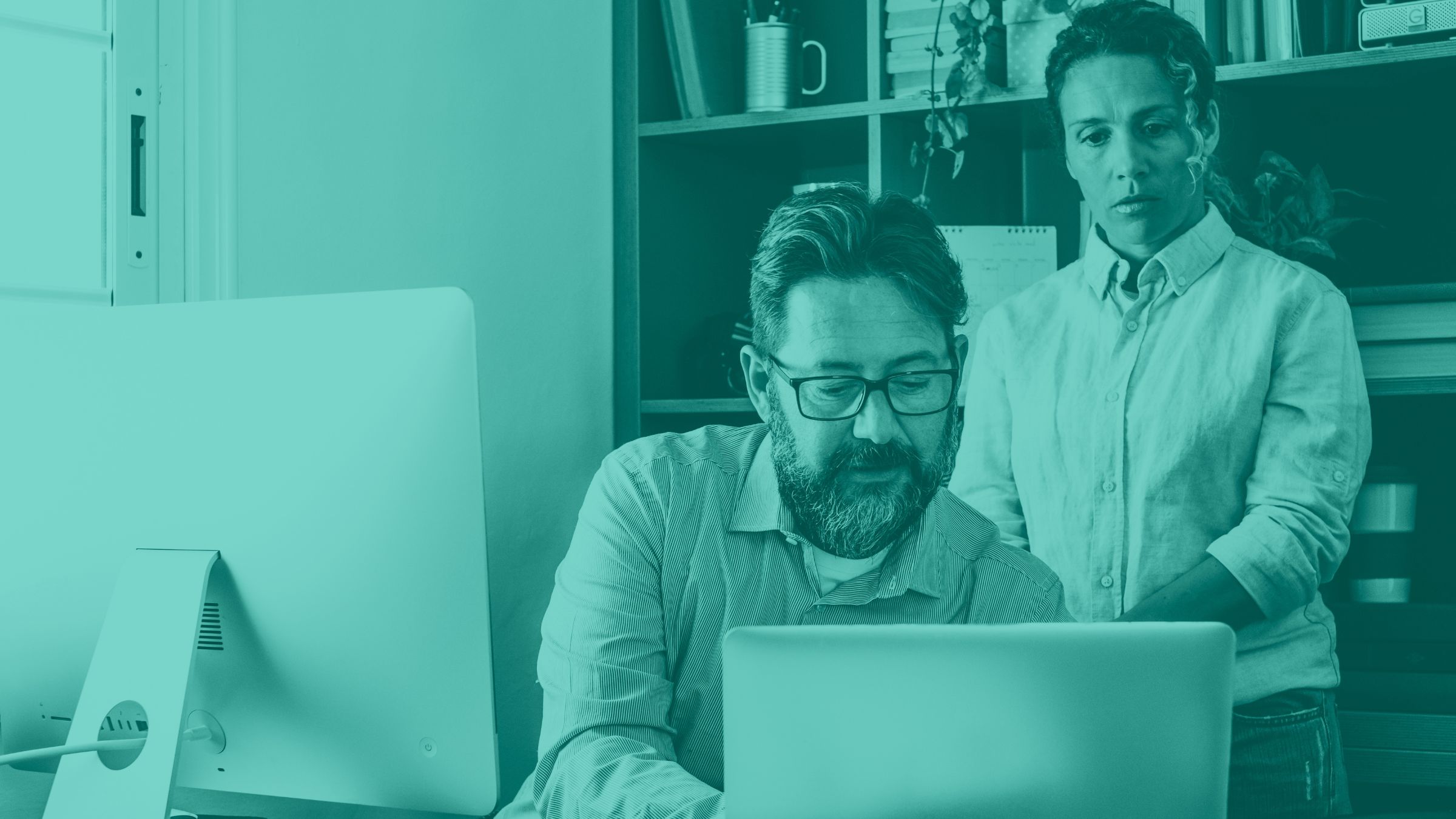two IT leaders looking at a Chromebook